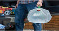 Silverline 159729 collapsible 20L water container with green handle and twist tap being carried outdoors